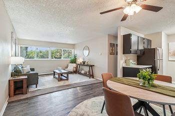 A well-lit, spacious living room with a dining area and a kitchenette